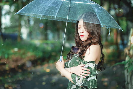 woman holding clear shade umbrella standing in shallow photography thumbnail