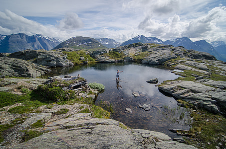 person wearing blue shorts standing in body of water during day thumbnail