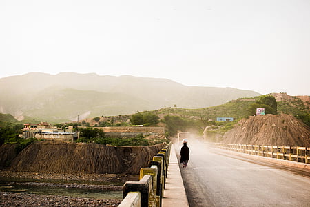 person walking on bridge during daytime thumbnail