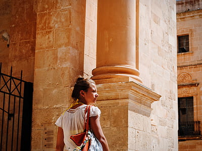 woman standing beside black steel gate during daytime thumbnail