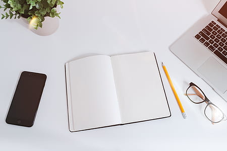 space gray iPhone 6 beside white book thumbnail