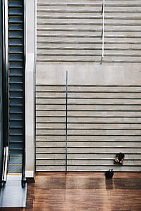 top view photography of two people sitting on staircase near escalator thumbnail