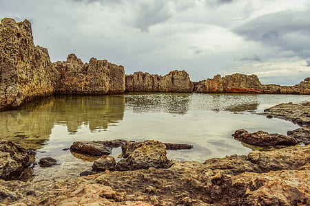 body of water on middle of rock formations thumbnail