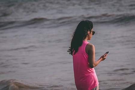 Woman Wearing Pink Tank Top Standing Near Sea Shore thumbnail