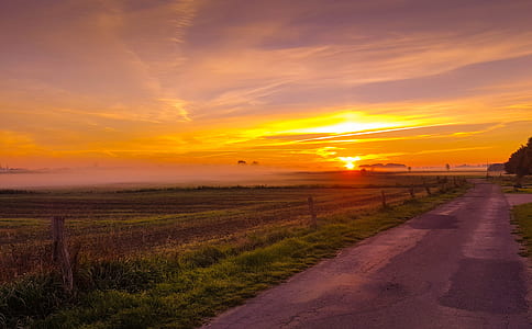 road near barbwire fence at sunset thumbnail