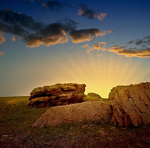 landscape photography of beige boulders under gray sky during golden hour thumbnail