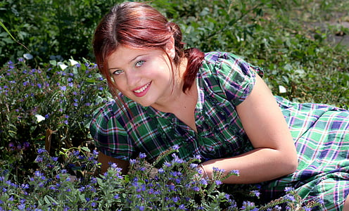 woman leaning into flowers during daytime thumbnail