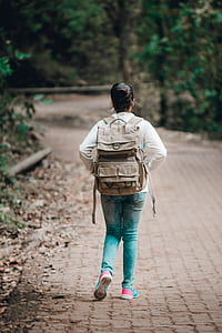 back view of woman wearing backpack on pathway thumbnail