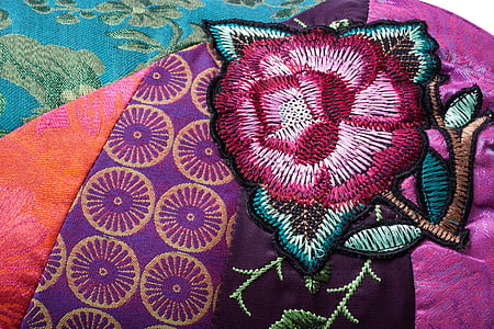 pink, black, and green floral mat on bed thumbnail