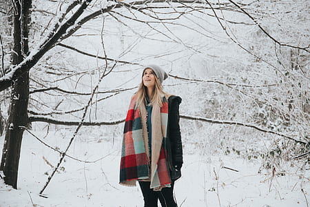 woman standing under a tree during snow thumbnail
