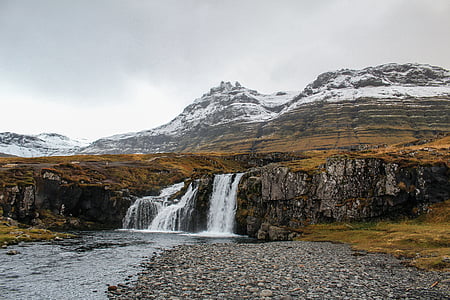 waterfalls on black and gray mountain under gray sky thumbnail