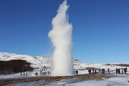 group of people standing near geyser during daytime thumbnail