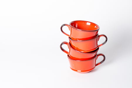 four orange ceramic cups on white surface thumbnail