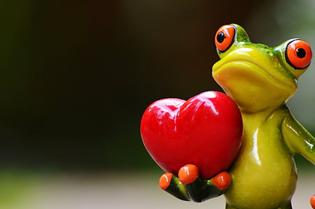 ceramic green frog carrying heart selective focus photography thumbnail