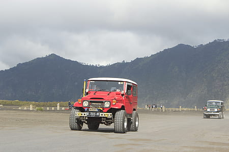 red vehicle at road during daytime thumbnail