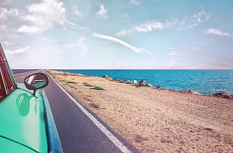 parked green car near seashore photo thumbnail