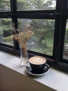 black ceramic teacup on saucer near window thumbnail