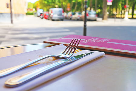 gray stainless steel fork and knife on white textile thumbnail