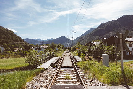 railway in the middle of mountains during daytime thumbnail