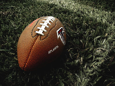 brown Atlanta football on green grasses thumbnail