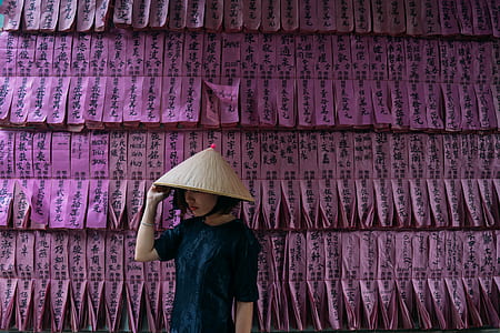 woman wearing brown wicker hat standing beside kanji text wall thumbnail