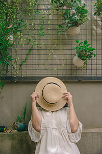 Person Wearing White Elbow-sleeved Top Covering Beige Sun Hat thumbnail
