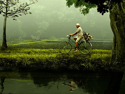 man riding black commuter bike driving beside body of water thumbnail
