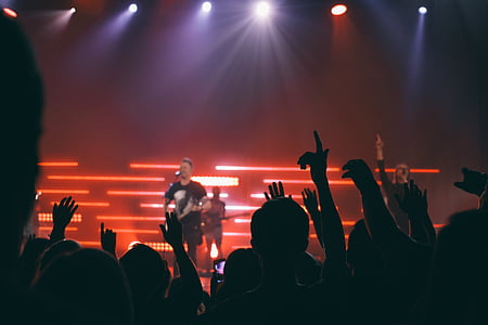 man singing on stage infront of crowd thumbnail