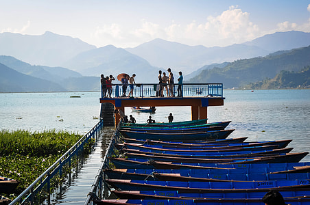 people standing near boats on blue body of water during daytime thumbnail