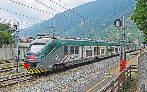silver and green bullet train on tracks thumbnail