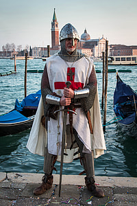 man holding long sword while standing in front body of water thumbnail