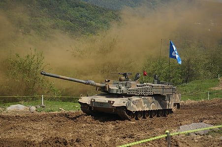 battle tank on road near trees during day thumbnail