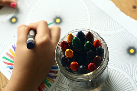 person holding blue color crayon thumbnail