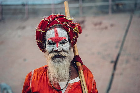man wearing red top holding brown stick thumbnail