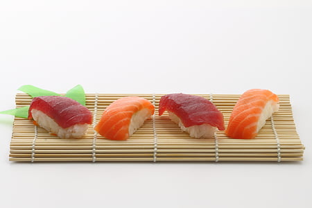 four salmon sushi on brown wooden mat thumbnail