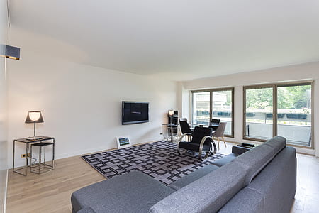 flat screen TV mounted on white wall near glass doors thumbnail