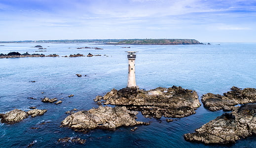 white lighthouse on rock formation thumbnail