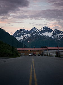 four assorted vehicles on road with mountain ahead at daytime thumbnail
