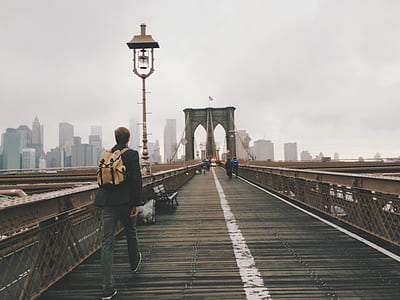 man walking on bridge during daytime thumbnail