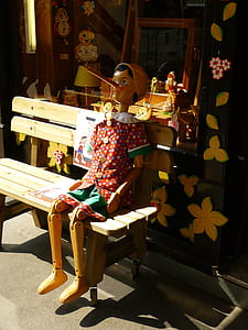 Pinocchio sitting on brown bench thumbnail