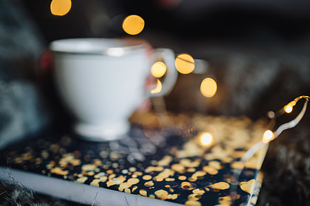 Young woman at home reading Hygge book and drinking thumbnail