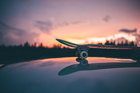 selective focus photography of skateboard during golden hour thumbnail