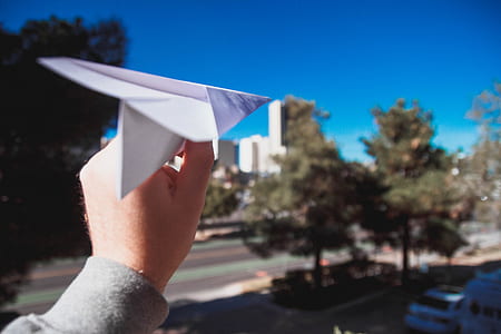 person holding white paper airplane thumbnail
