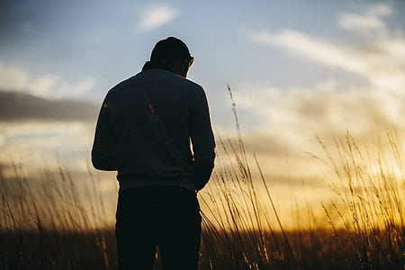 silhouette of man standing on grass thumbnail