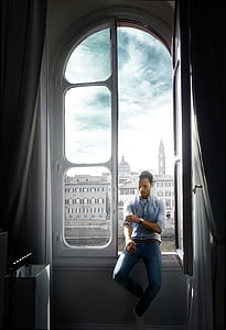 man sitting on window fixing his sleeve with building background thumbnail