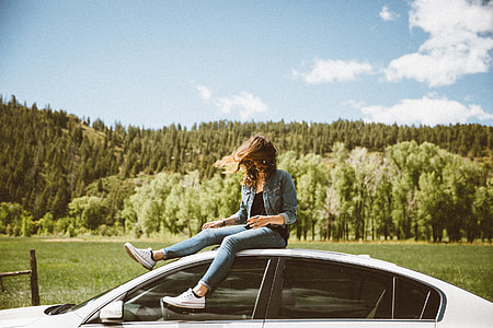 woman sitting on top of white car thumbnail