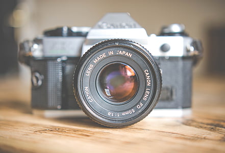 gray and black single-lens reflex camera on brown surface thumbnail