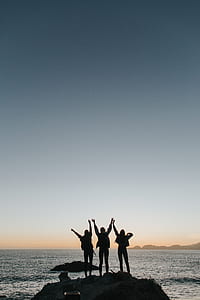three person standing near sea raising their hands thumbnail