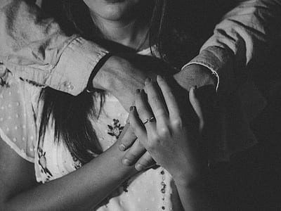 grayscale photo of girl holding hand to person at her back thumbnail