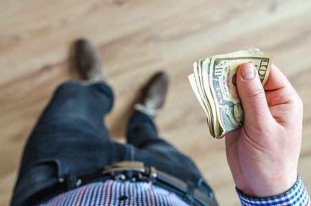 person holding bundle of banknotes thumbnail